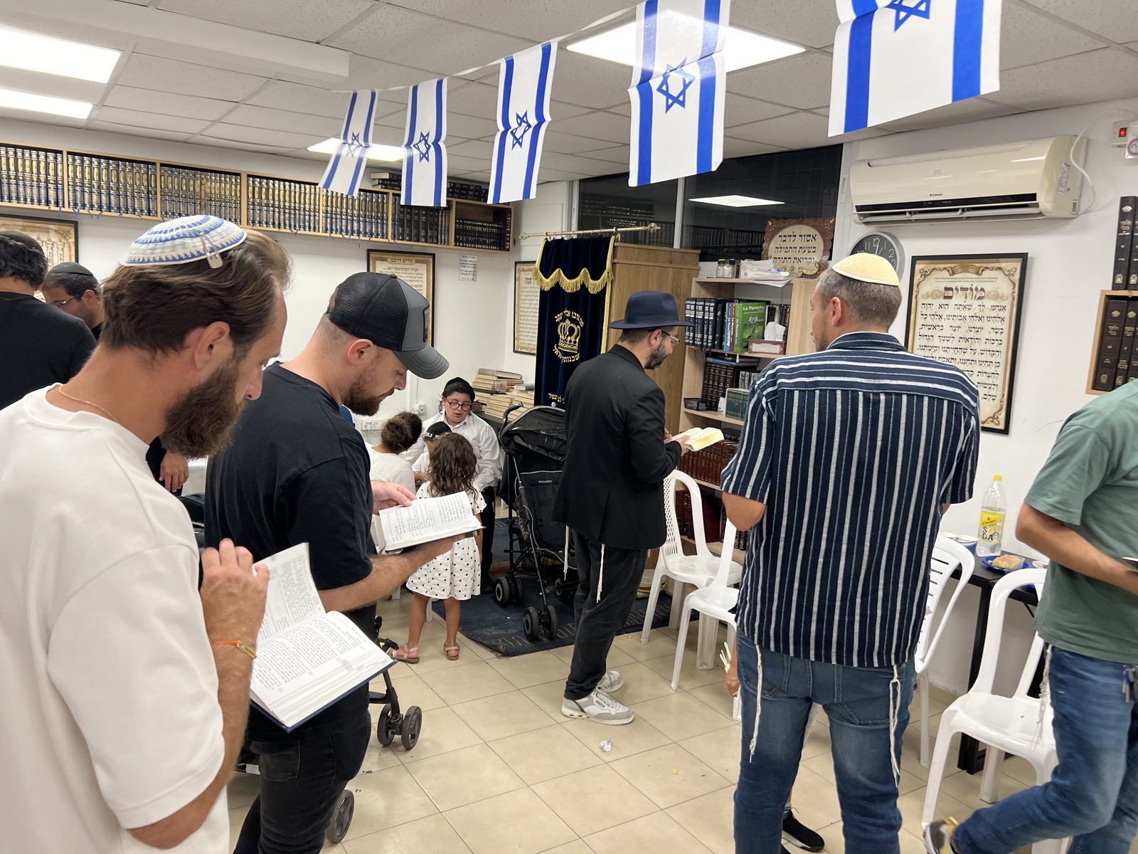 Office sous les guirlandes de drapeaux israéliens, sidour en main