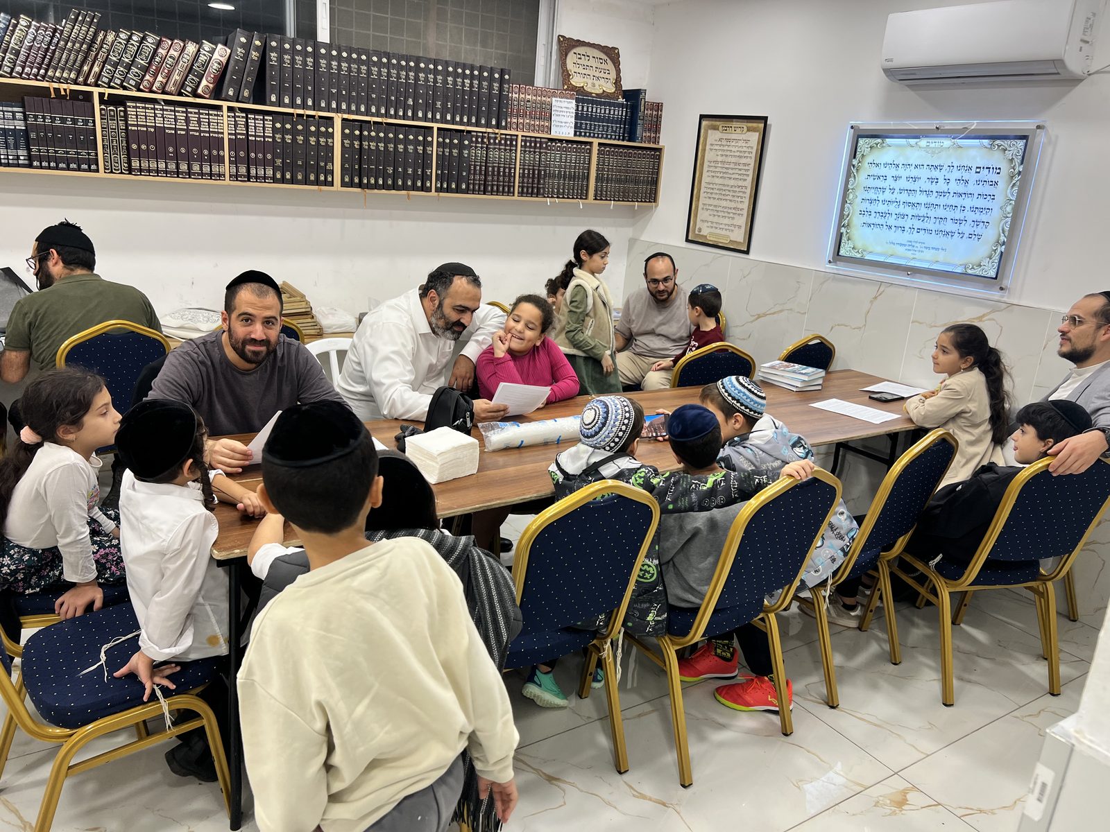 Vue large d’une session Avot Oubanim : pères et enfants par petits groupes autour des tables