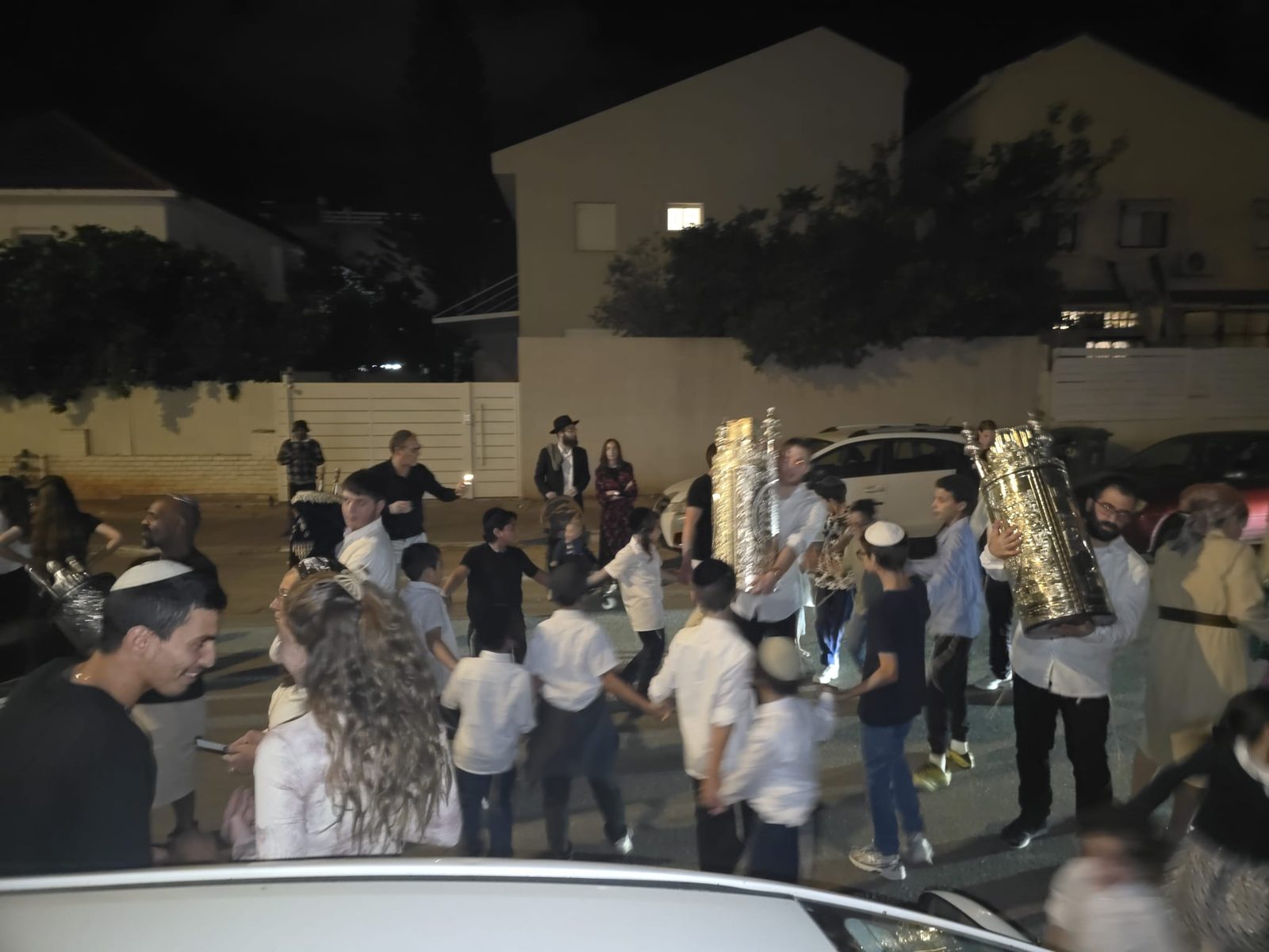 Ronde nocturne dans la rue autour de deux sifrei Torah lors des Hakafot Chniyot