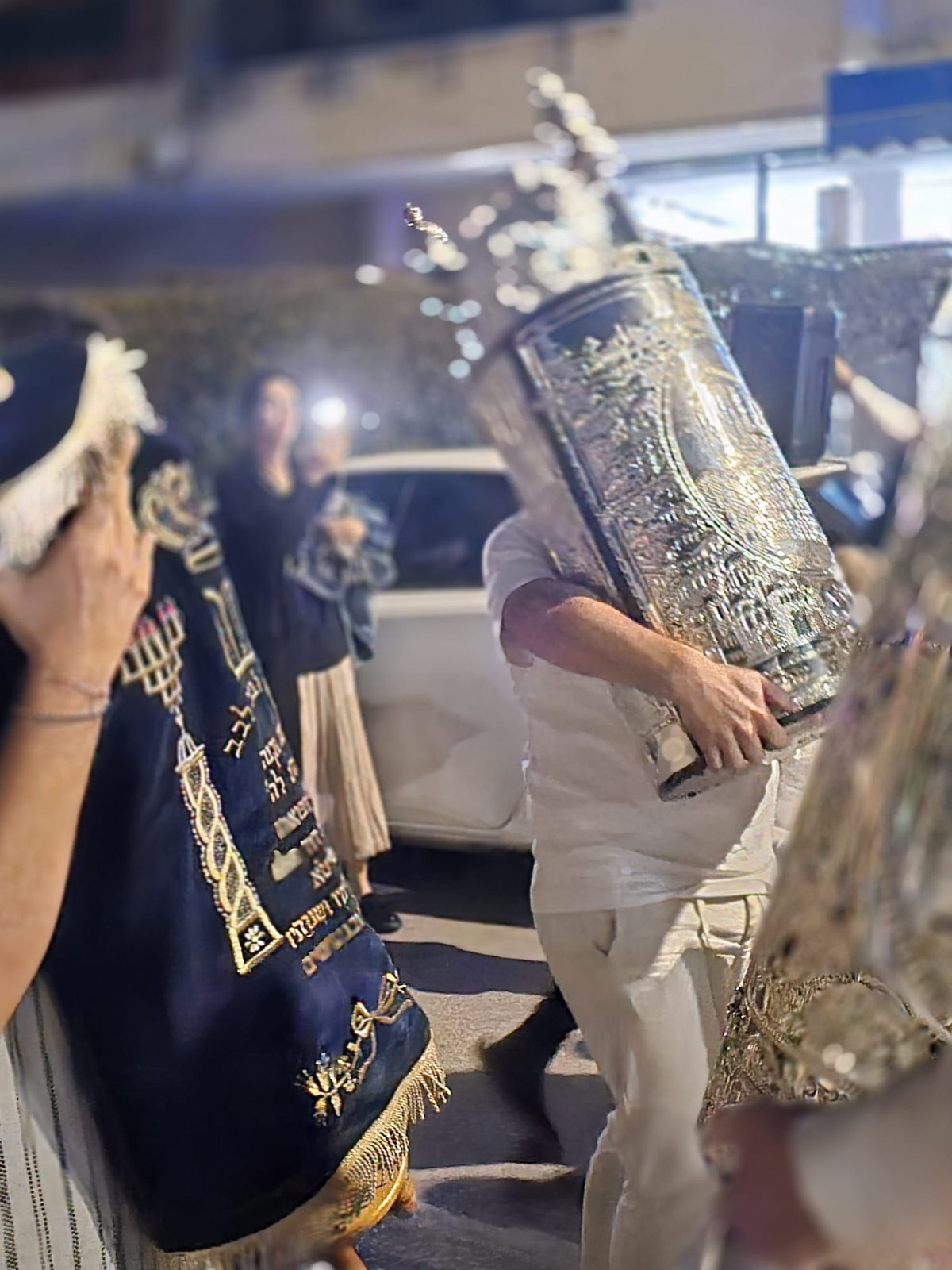 Sefer Torah à l’étui argenté porté à l’épaule pendant la procession des Hakafot Chniyot