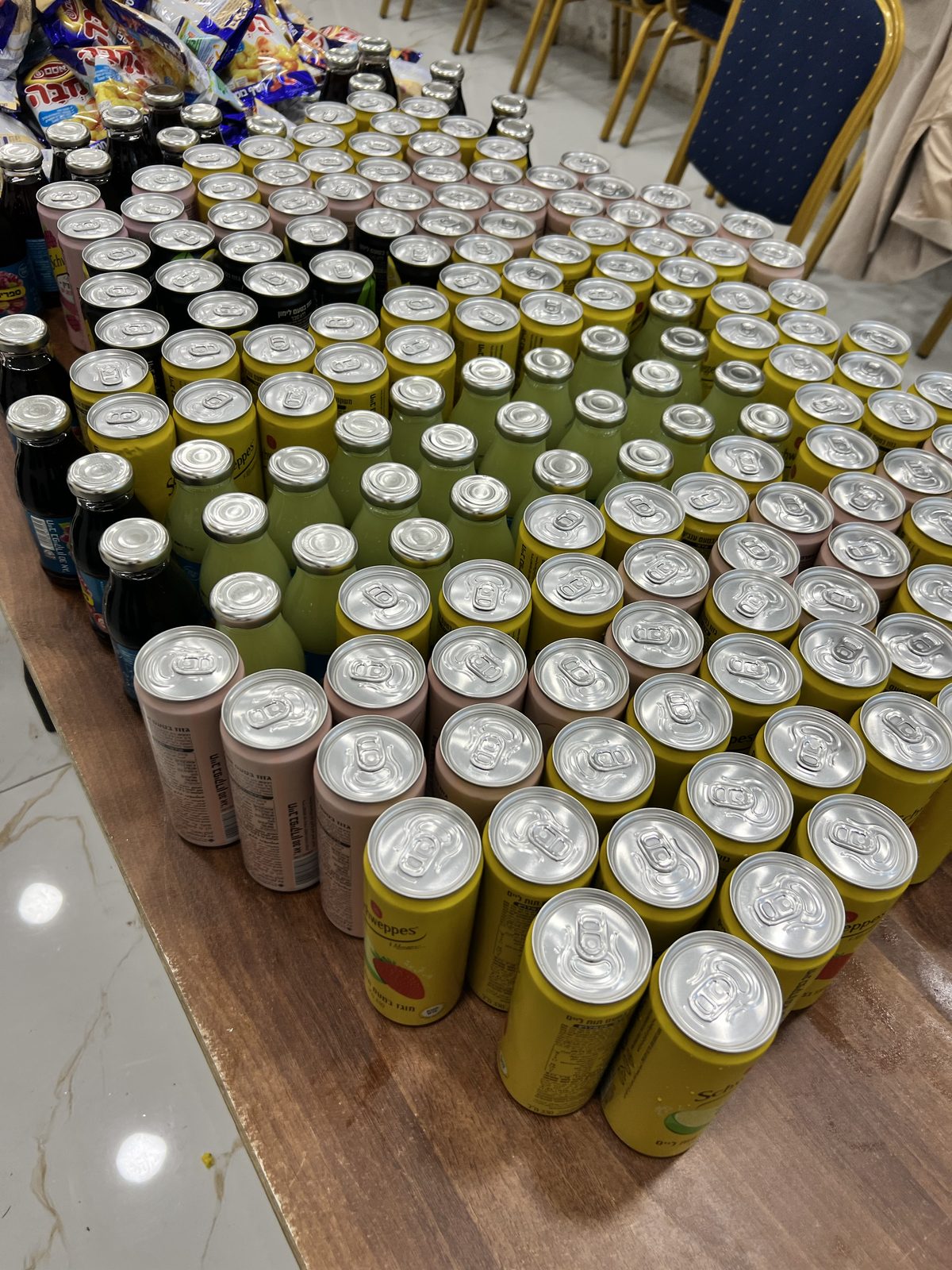 Canettes et bouteilles alignées sur une table pour la préparation des colis