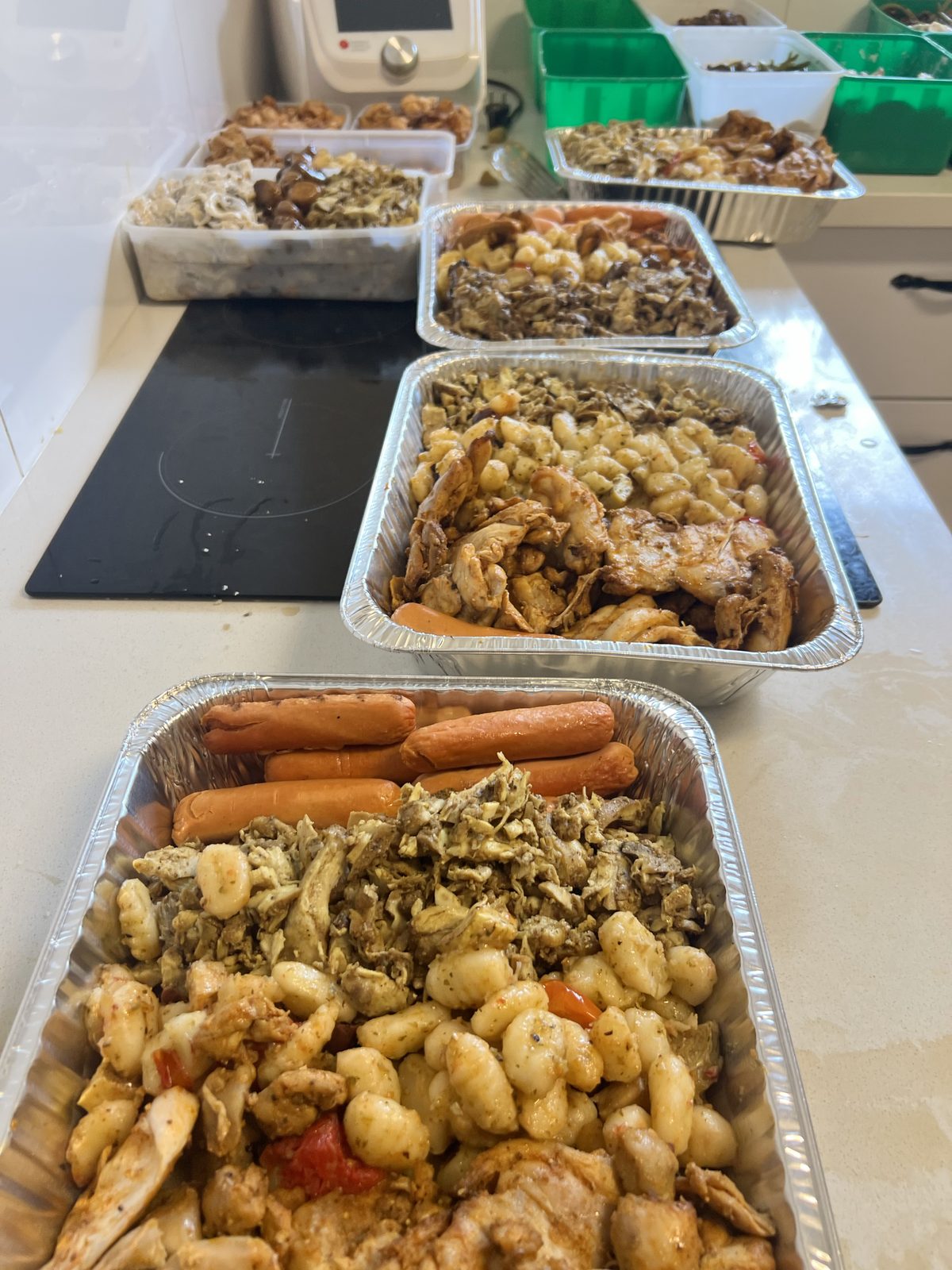 Grands plateaux de repas en cours de préparation dans la cuisine communautaire