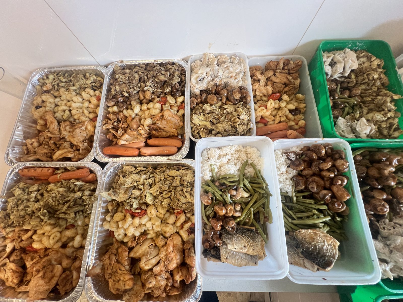 Plateaux familiaux et barquettes individuelles côte à côte, prêts pour la distribution